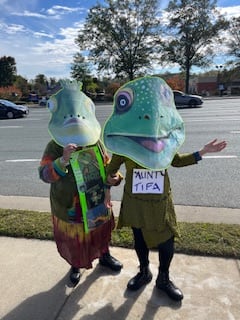 Two people wearing frog masks AI-generated content may be incorrect.
