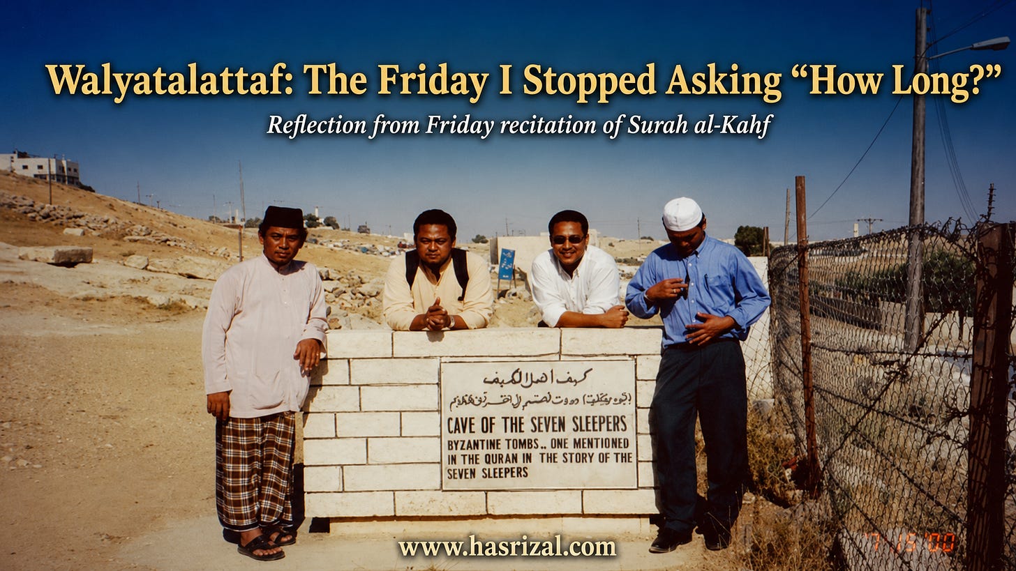 A wide landscape photograph-style image showing four Malaysian men visiting the Ashab al-Kahf location in Jordan in the year 2000. They stand and lean around a stone sign that reads “Cave of the Seven Sleepers,” with Arabic and English text. The background shows a dry desert landscape, clear blue sky, roadside fencing, and distant buildings. Large title text across the sky reads, “Walyatalattaf: The Friday I Stopped Asking ‘How Long?’” with the subtitle “Reflection from Friday recitation of Surah al-Kahf.” The website “www.hasrizal.com” appears at the bottom centre.