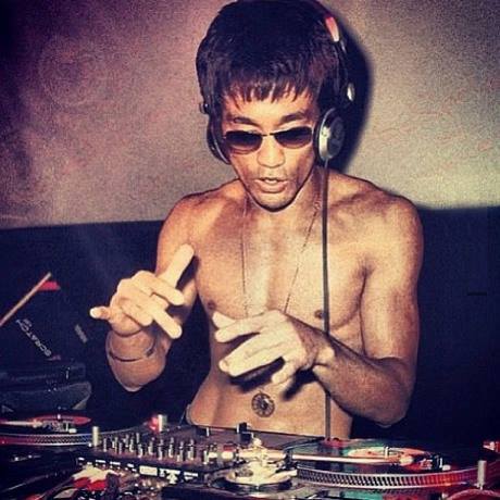 retro 70s color photograph of Bruce Lee photoshopped to appear as if he's spinning turntables
