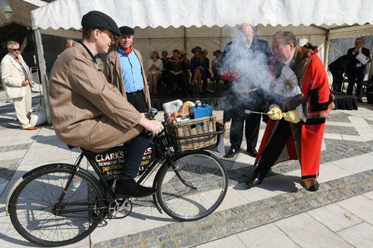 A man riding a bicycle while it's branded with a hot poker