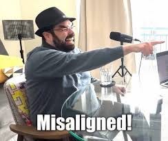 Man in hat pointing sideways, captioned