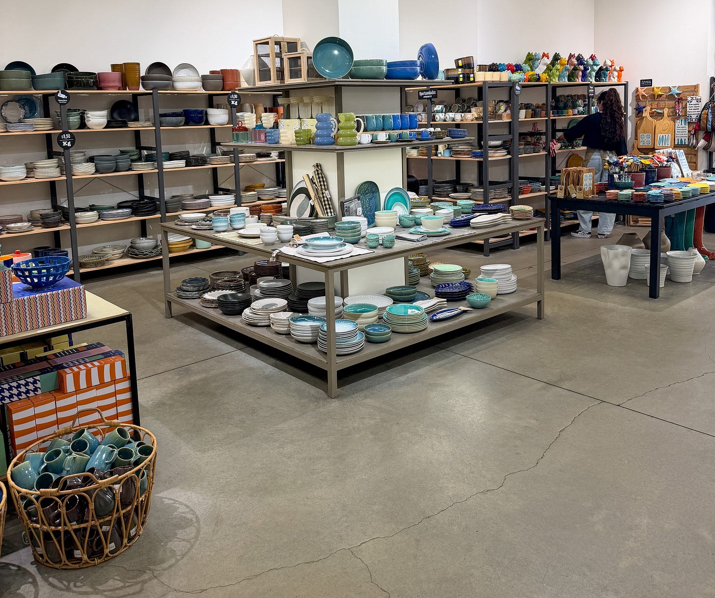 Shelves and display tables filled with colorful Portuguese ceramics, bowls, and pottery at Ceramics na Linha in Lisbon