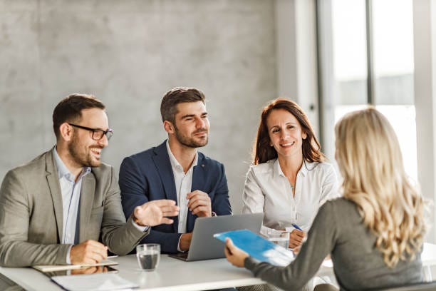Happy human resource team talking to a candidate on a job interview.