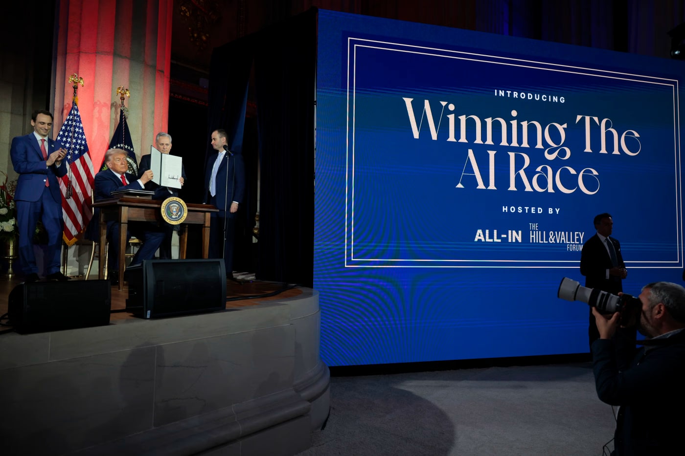 Trump displaying an executive order at the “Winning the AI Race” summit. Source __T3A_LINK_IN_POST__.