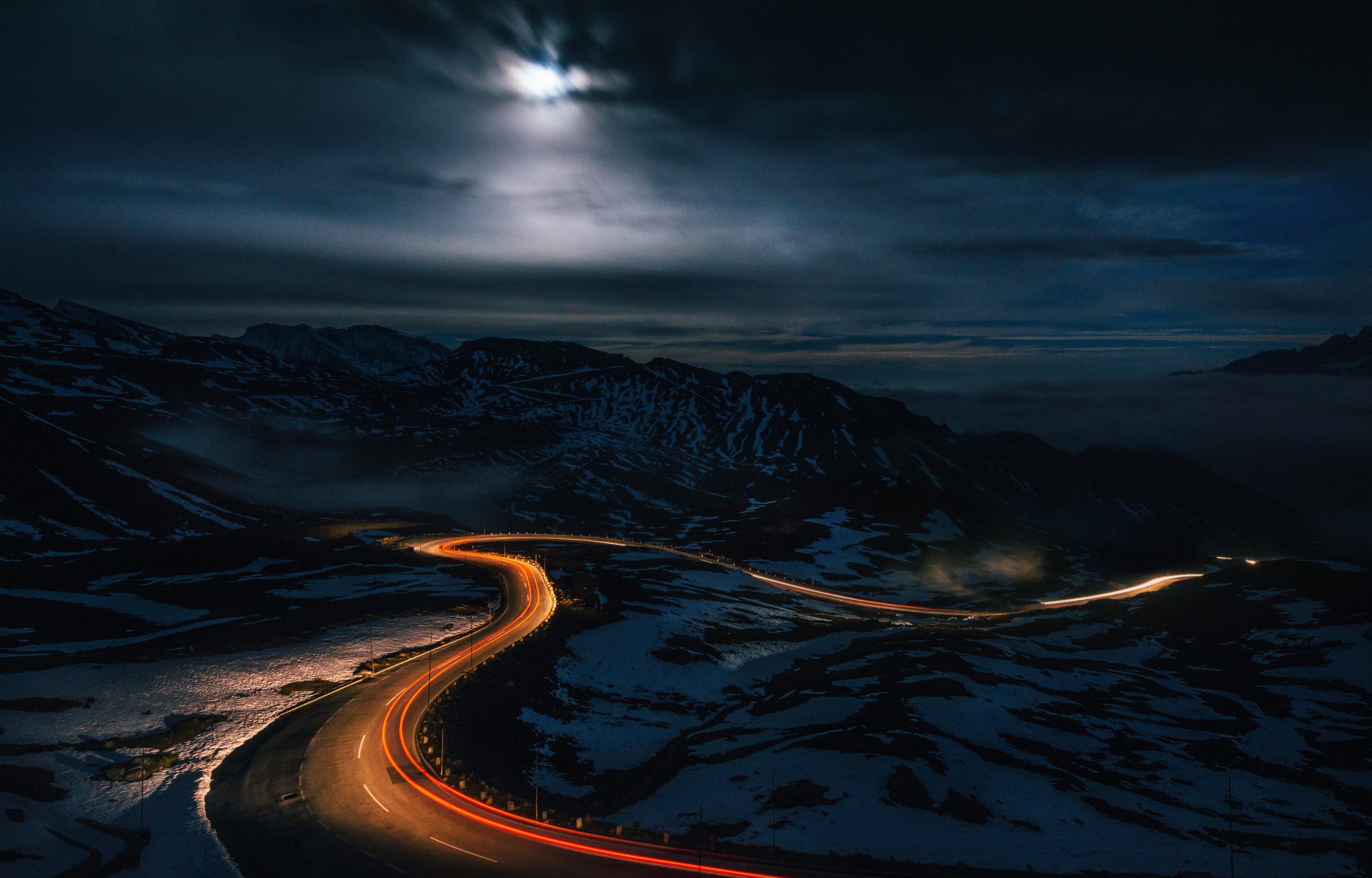Перевал ночь давно. Фото зимняя туманная Извилистая дорога со следами фар.