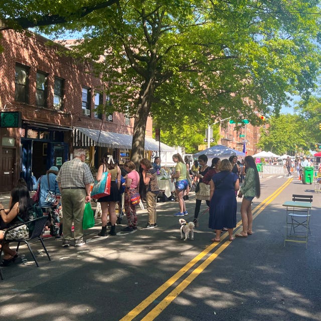 People crowd around vendor at 31st Avenue Open Street Astoria