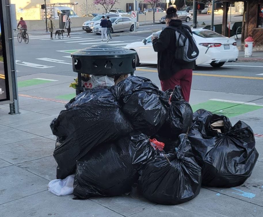 Heap of plastic trash bags on curb waiting for sanitation pickup