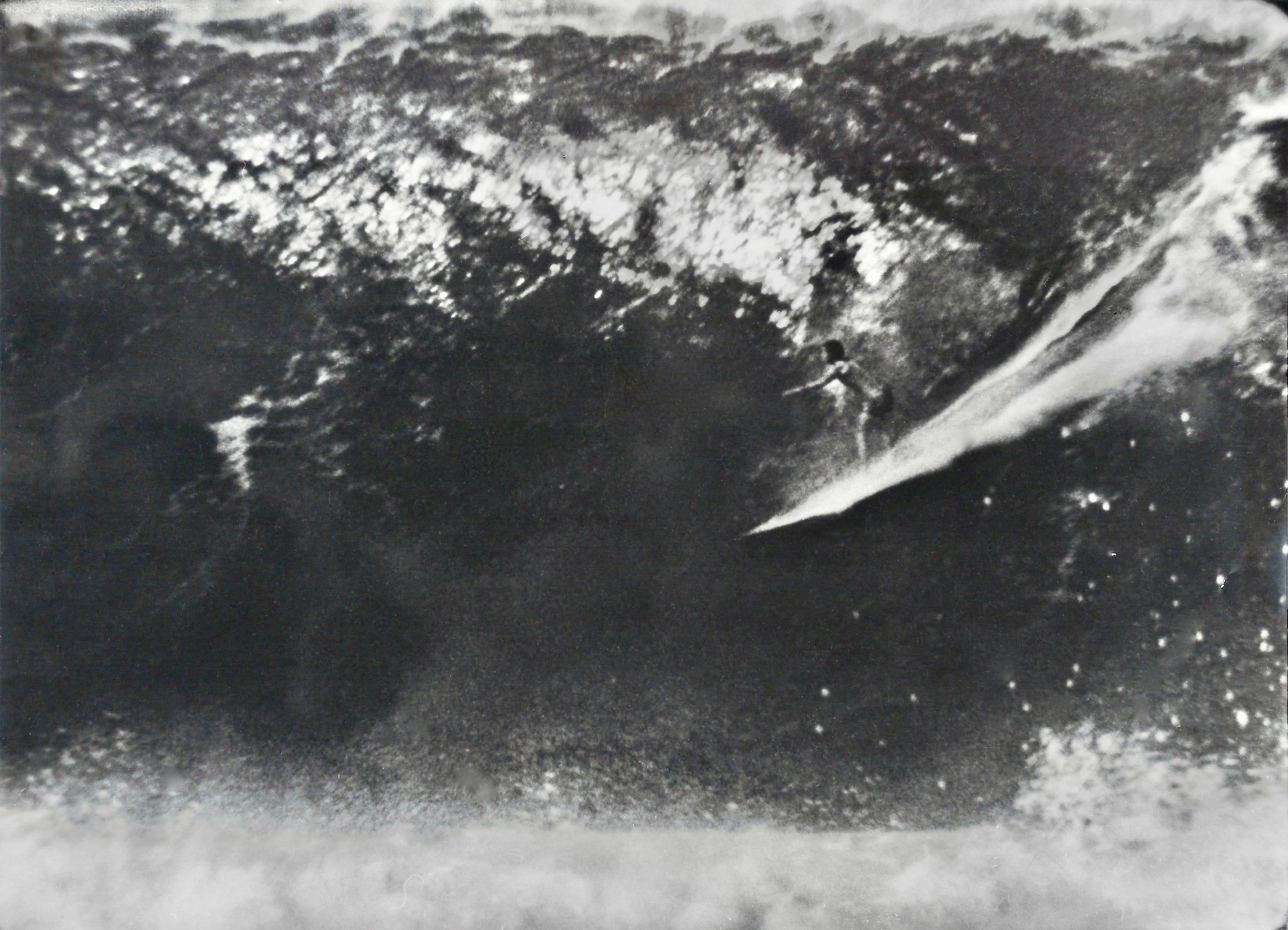 A photo of a man spear fishing in Hawaii, at night, in the 1940s