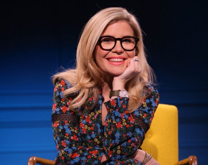 Emma Barnett, wearing a floral dress and smiling at the camera