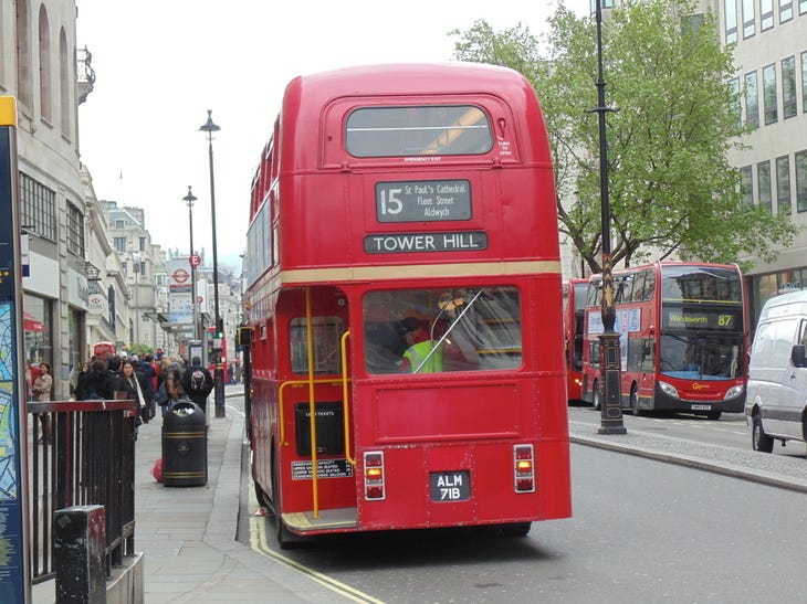 A vintage London bus driving away