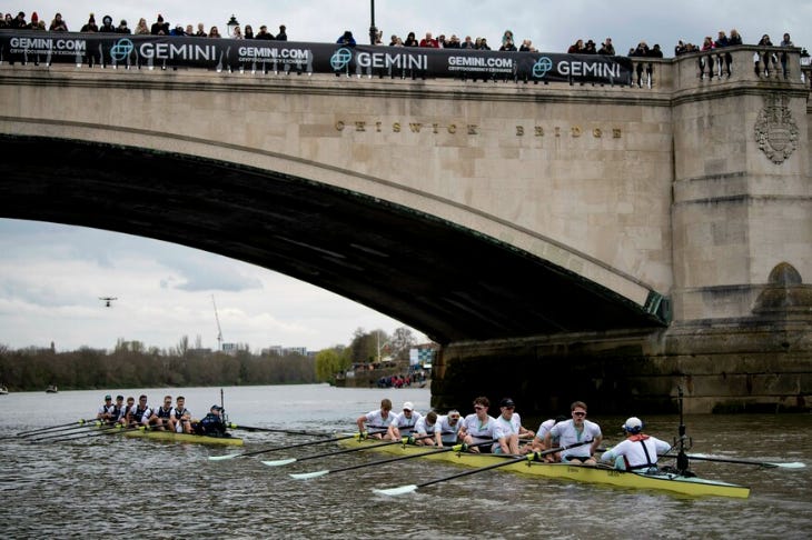 Two boats being rowed beneath a bridge on the Thames