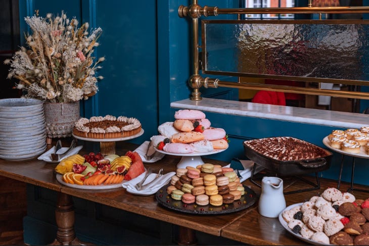 Fruits, macarons and cakes laid out at a buffet