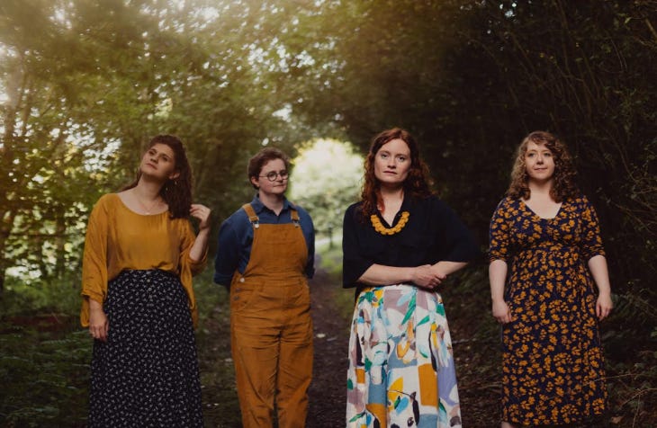 Four women posing for a photo in woodland