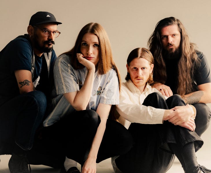 Four members of the band Dry Cleaning posing for a photo