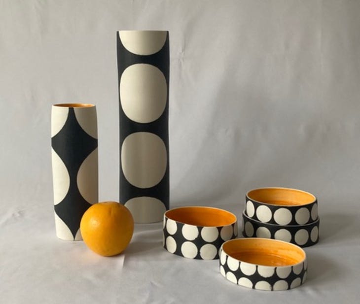 A display of black and white dotty bowls and vases