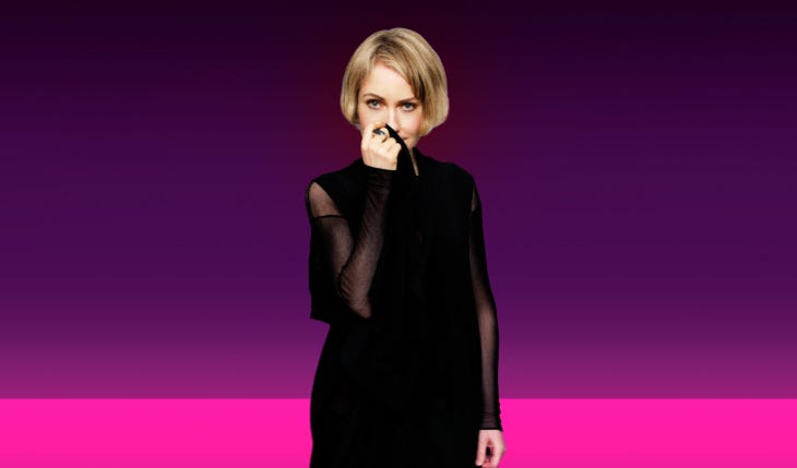 Emily Saunders, dressed in black against a purple background