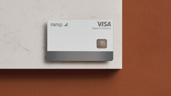 A Ramp Visa Signature Business card is placed on a white and brown surface