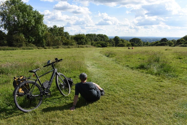 A man with an ebike in the countryside, which is actually in London