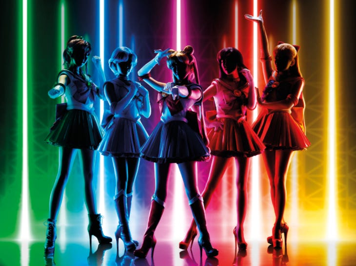 Sailor Moon: five people silhouetted in front of rainbow lights