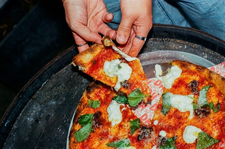 A pizza slice being pulled away