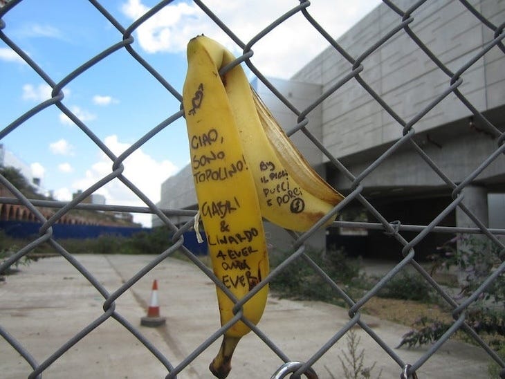 A graffited banana skin on a fence