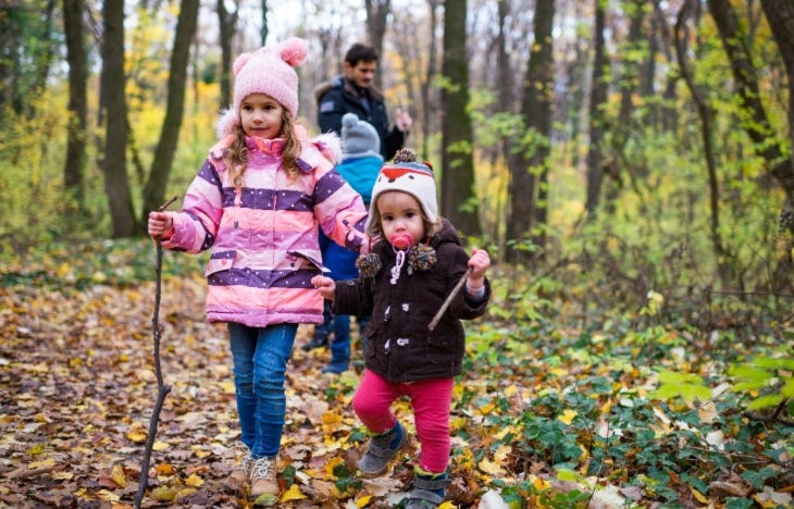 A family wrapped up for winter walking through woodland