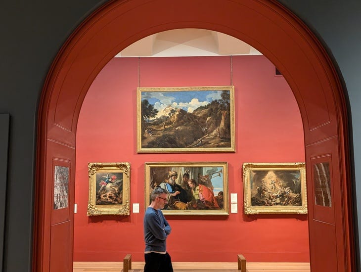 A man strolling through an art gallery