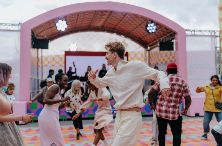 People dancing in front of a festival stage