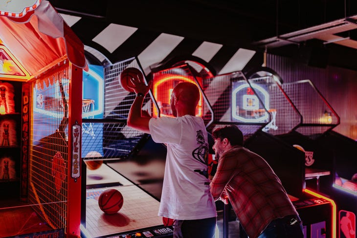 People playing a basketball arcade game