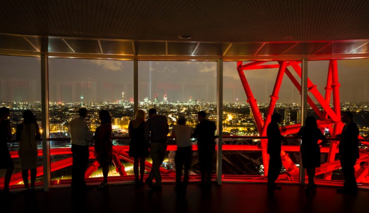 People looking out at London at night, from the ArcelorMittal Orbit viewing platform