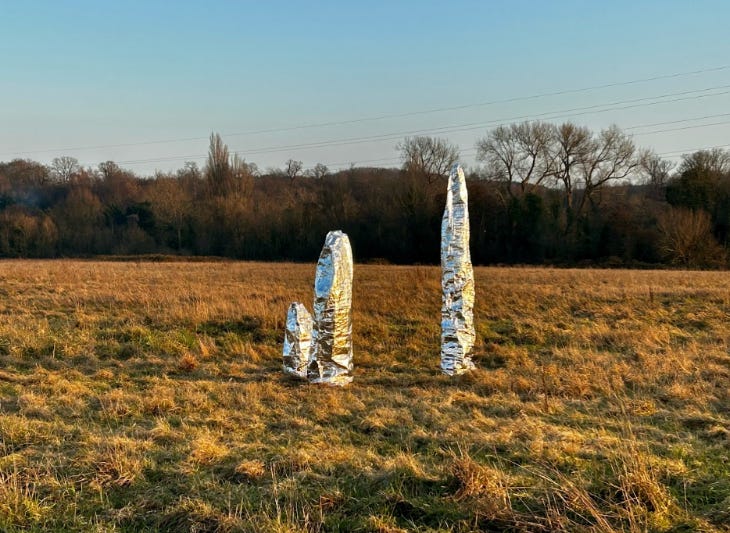 Three white pillars in a field