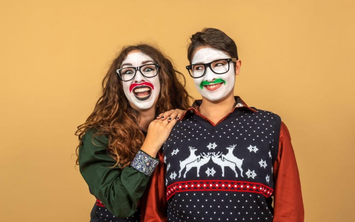 Two actors wearing white clownish makeup