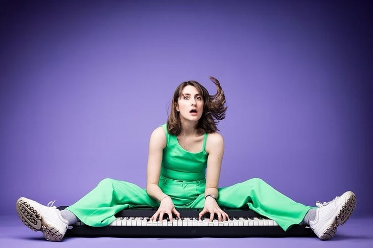 A person in a green jumpsuit playing a keyboard