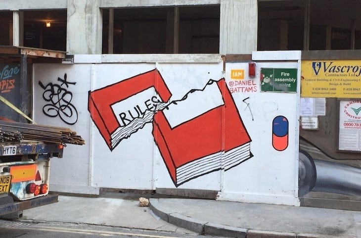 Street art of a rule book torn in two