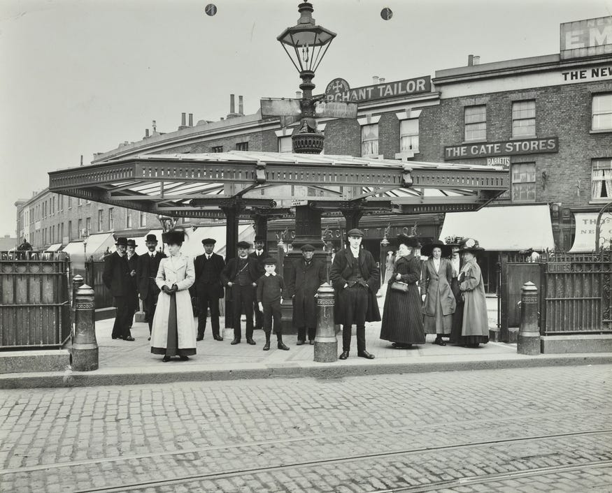 A black and white photo of people waiting for a tram at New Cross in 1922.