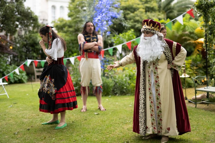 People acting in a garden square in Shakespearian costumes