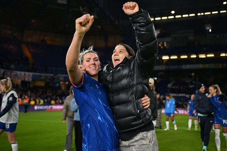 Players celebrating on the pitch after a win