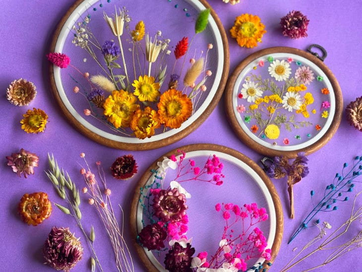 A display of embroidery hoops with pressed flowers