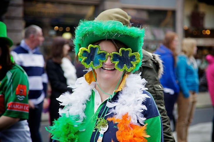 A woman wearing shamrock sunglasses at the St Patrick's Day Parade