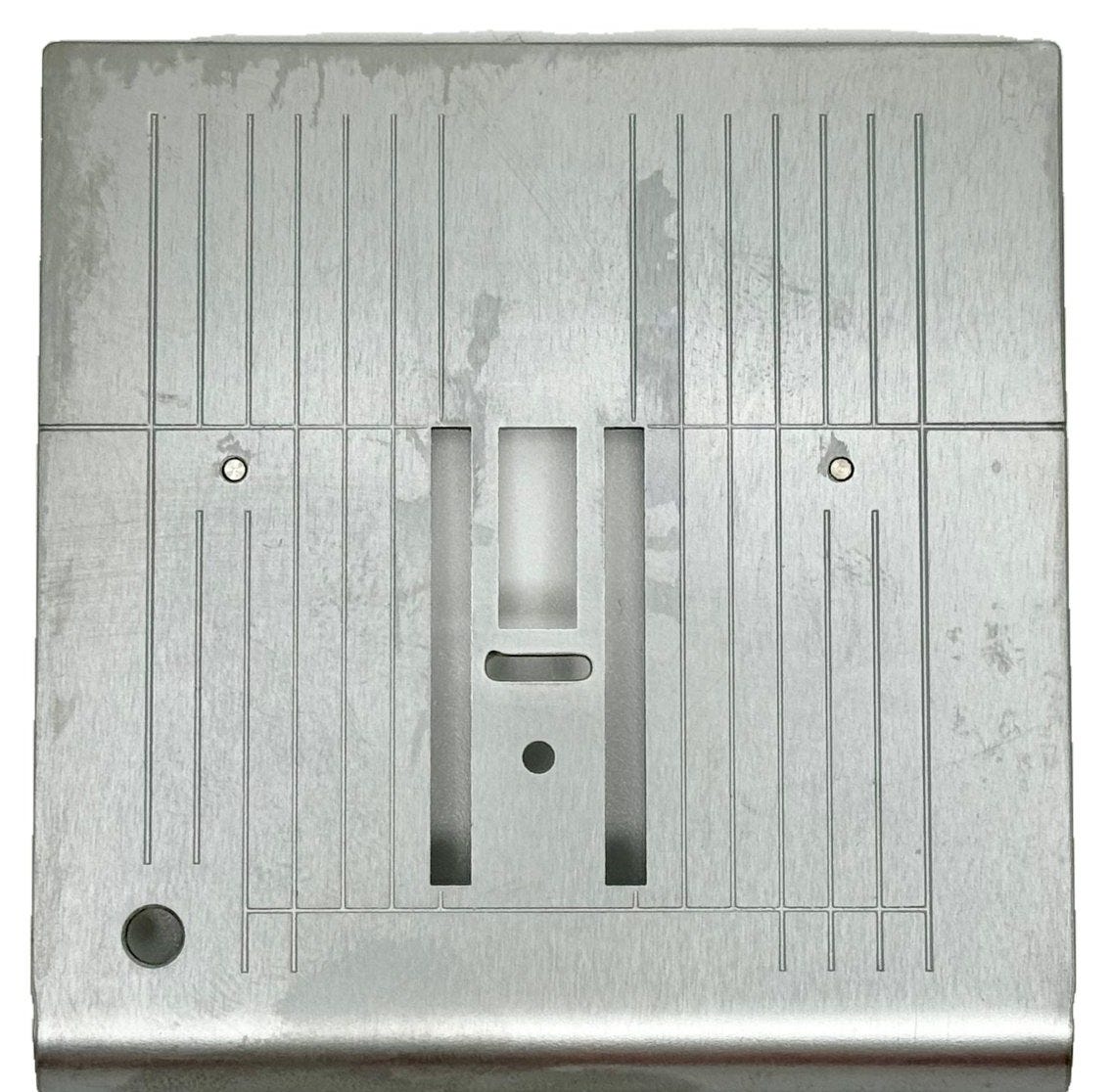 Sewing machine needle plate showing the width of the needle hole