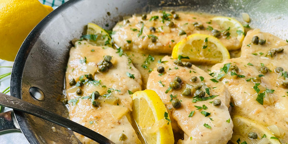 Chicken breast in a lemon and wine sauce with capers, minced parsley and lemon slices.