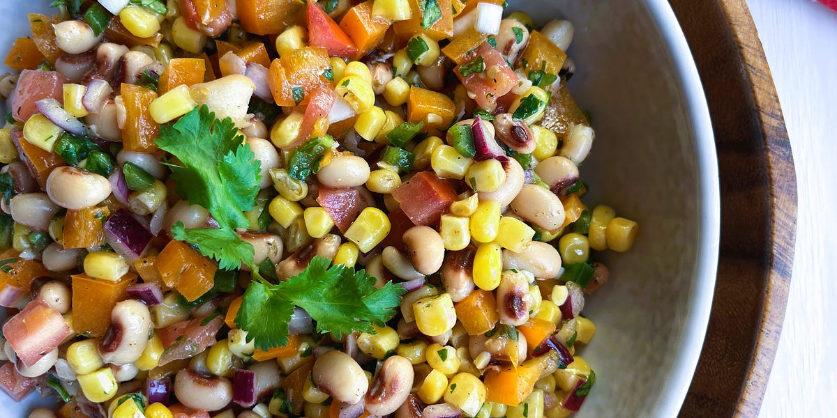 Salsa of black-eyed peas, corn, tomatoes, bell pepper, red onion and cilantro in a white bowl.