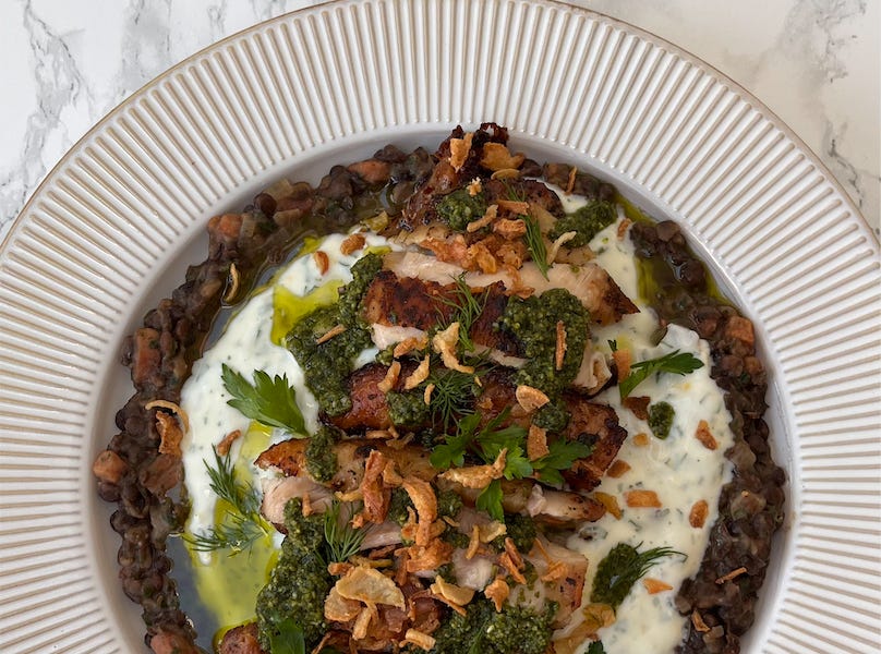 Crispy chicken with pancetta, herby lentils, lemony yoghurt and pesto