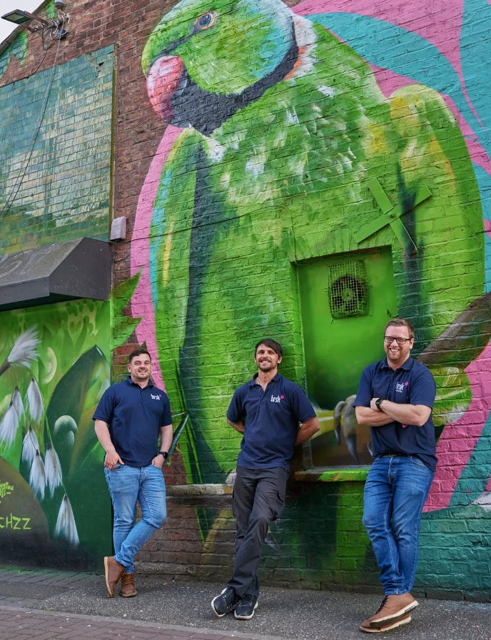 Brsk’s engineers in action. Well, posing in front of a giant green parakeet — an artwork by @_peachzz_ that is part of the amazing Withington Walls project.