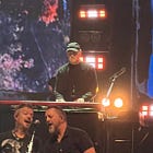 Rick Carlisle behind a piano, on stage with artists and dedicating a song to a former colleague