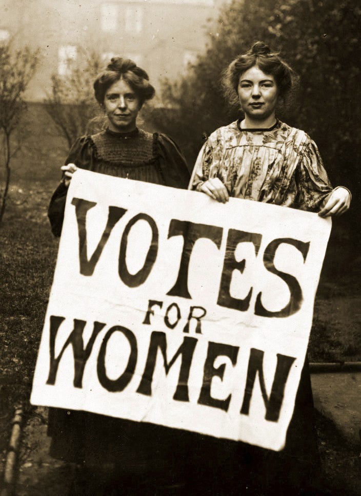 Two young women holding a Votes for Women placard