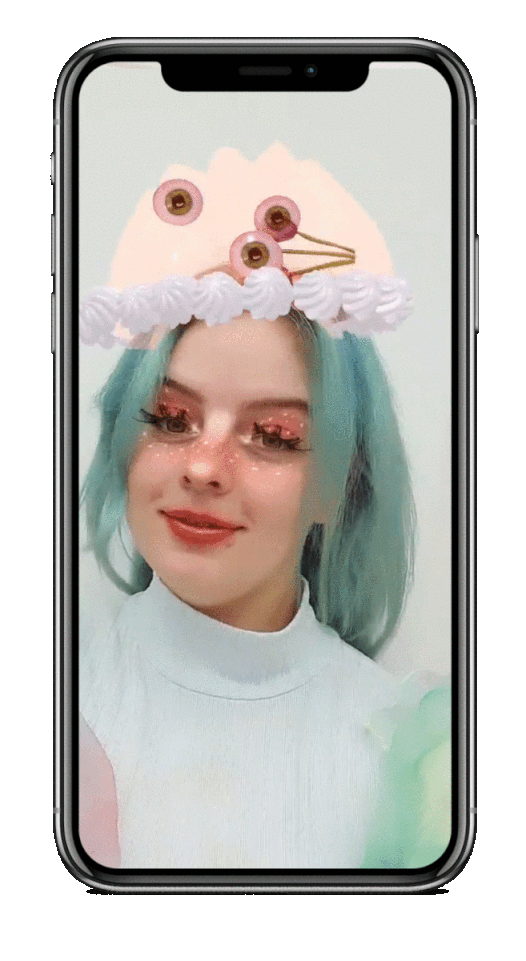 GIF of augmented reality filter featuring a young woman with blue hair in a white mock neck top. She is making an expression while glitter makeup, eyelashes and a jelly-like shape featuring eyeballs moves around her head.