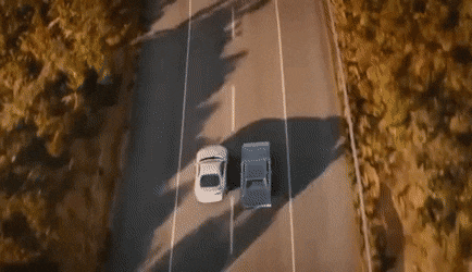 A gif of two cars driving and diverging, one taking the exit, the other continuing down the road.