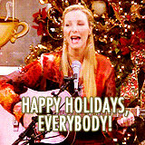 Phoebe Buffay di Friends che suona la chitarra di fronte a un albero di Natale e dice "HAppy Holidays Everybody!"