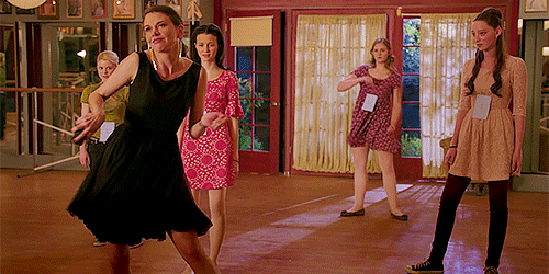 Sutton Foster doing a dance kick on Bunheads while four teenage girls watch
